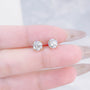Close-up of Classic Four-Prong round lab-grown diamond stud earrings with yellow gold prongs