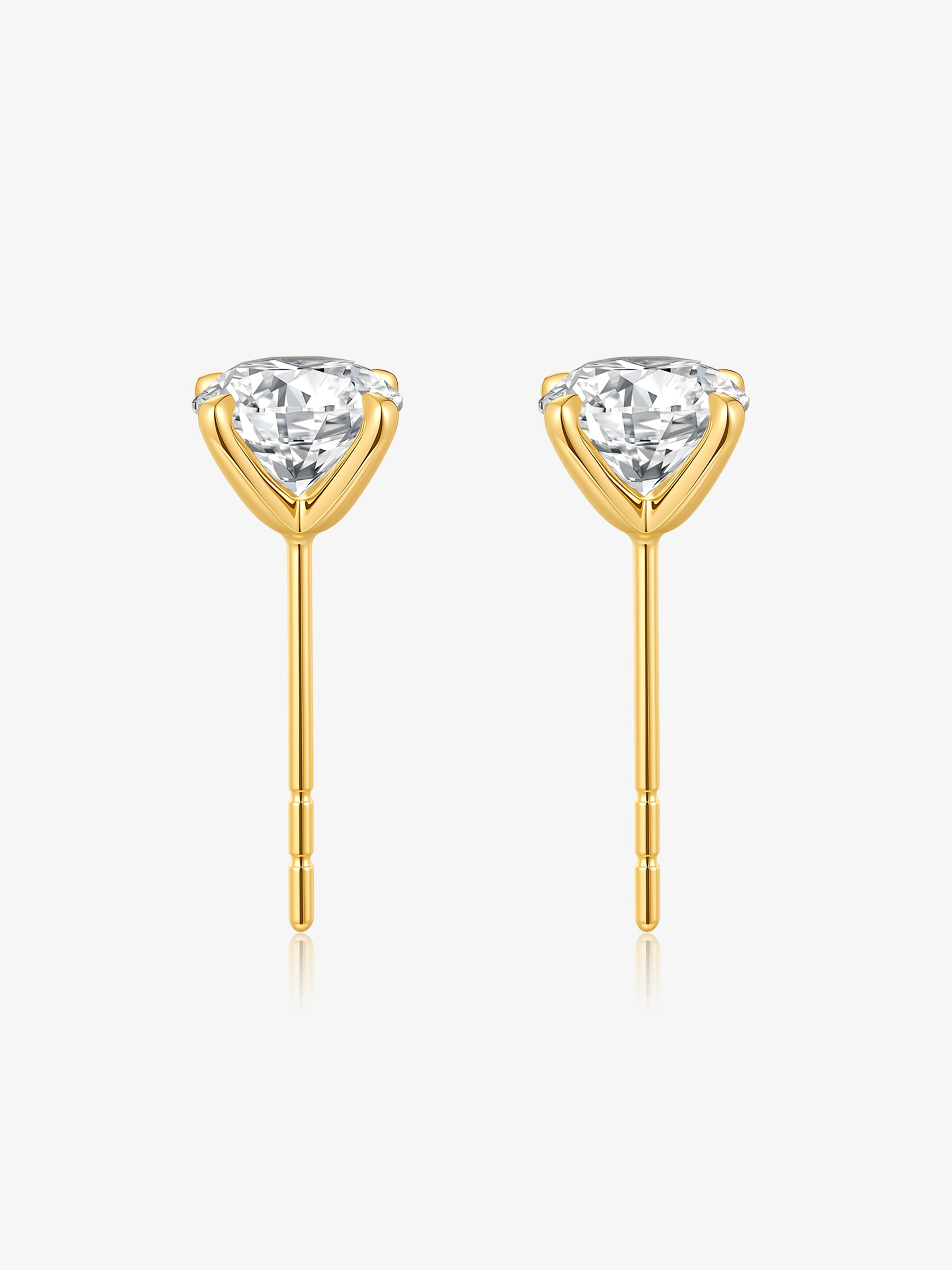 Detail view of round lab-grown diamond stud earrings in four-prong yellow gold settings