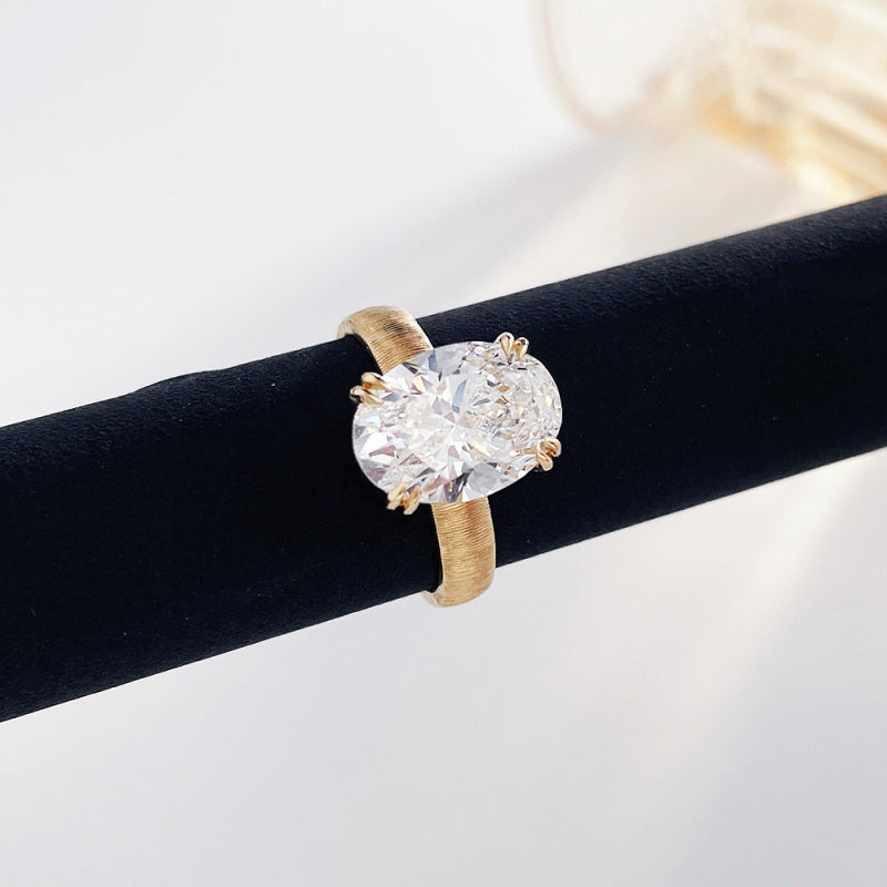 Close-up of the Golden Oval lab-grown diamond engagement ring with an oval center diamond and textured yellow gold band
