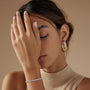 Model wearing a lab-grown diamond tennis bracelet with round brilliant diamonds, approximately 0.10ct each