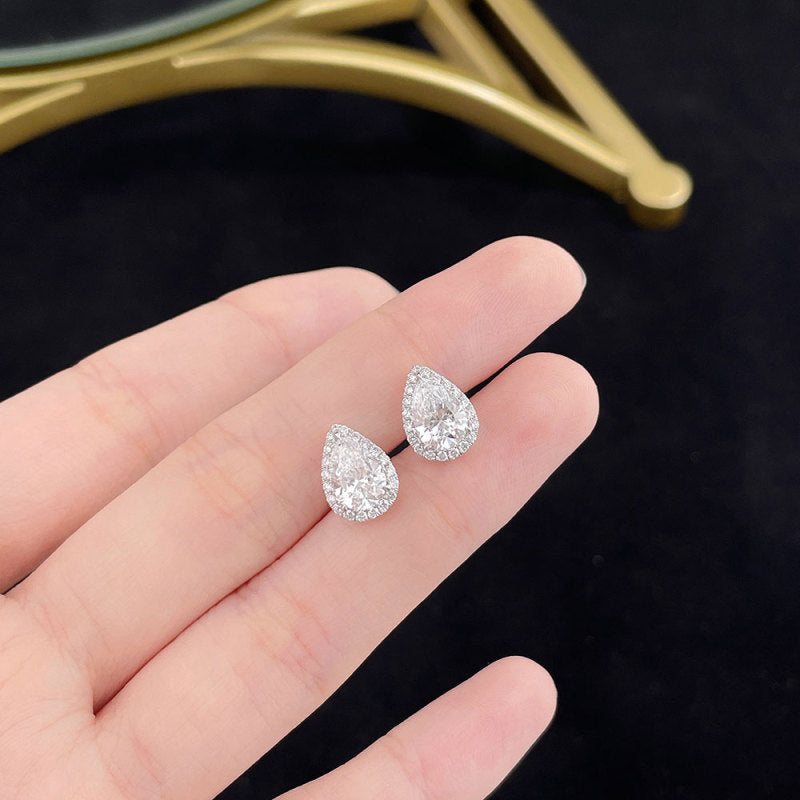 Close-up of Pear Halo lab-grown diamond stud earrings with pear-cut diamonds and round diamond halos
