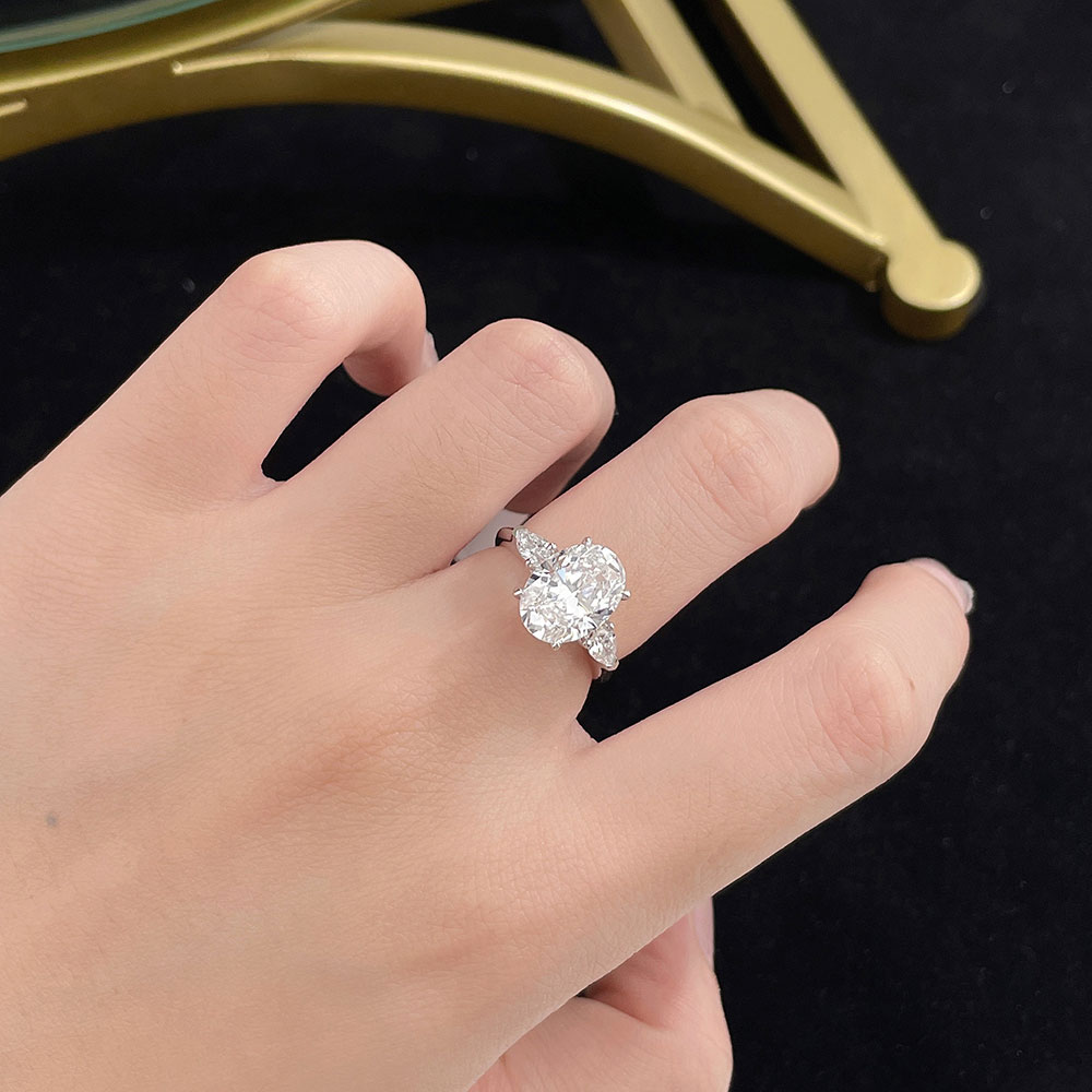 Model wearing the Soft Oval Trio lab-grown diamond engagement ring with an oval-cut center diamond and side stones